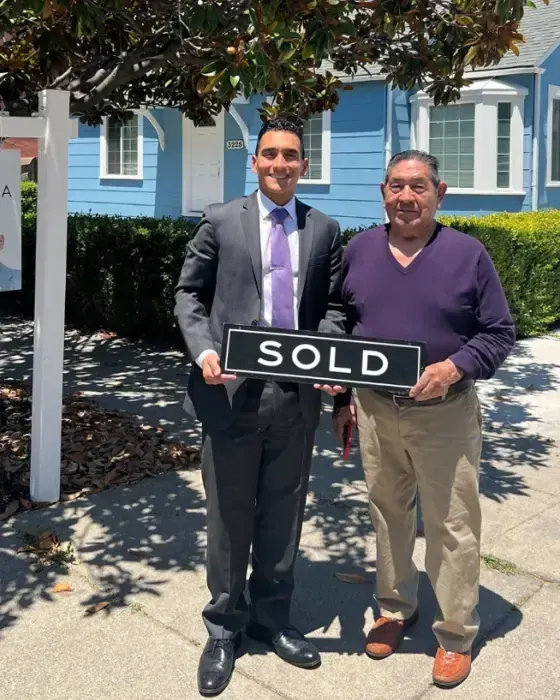 Nestor Icaza's clients holding a SOLD sign on closing day for their San Bruno or Peninsula home